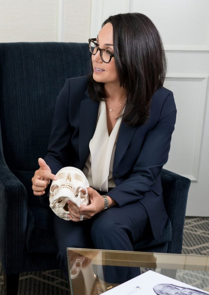 Dr. Caitlin Magraw holding a skull model during a consultation